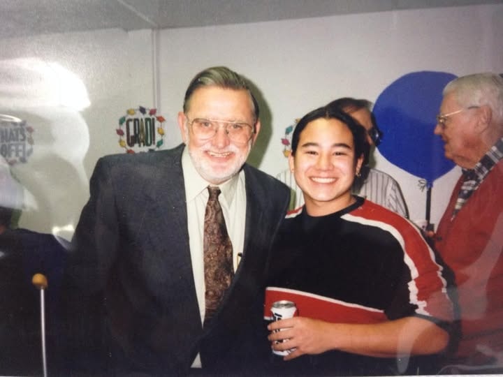 Founder posing with a Class of 1997 graduate at graduation celebration