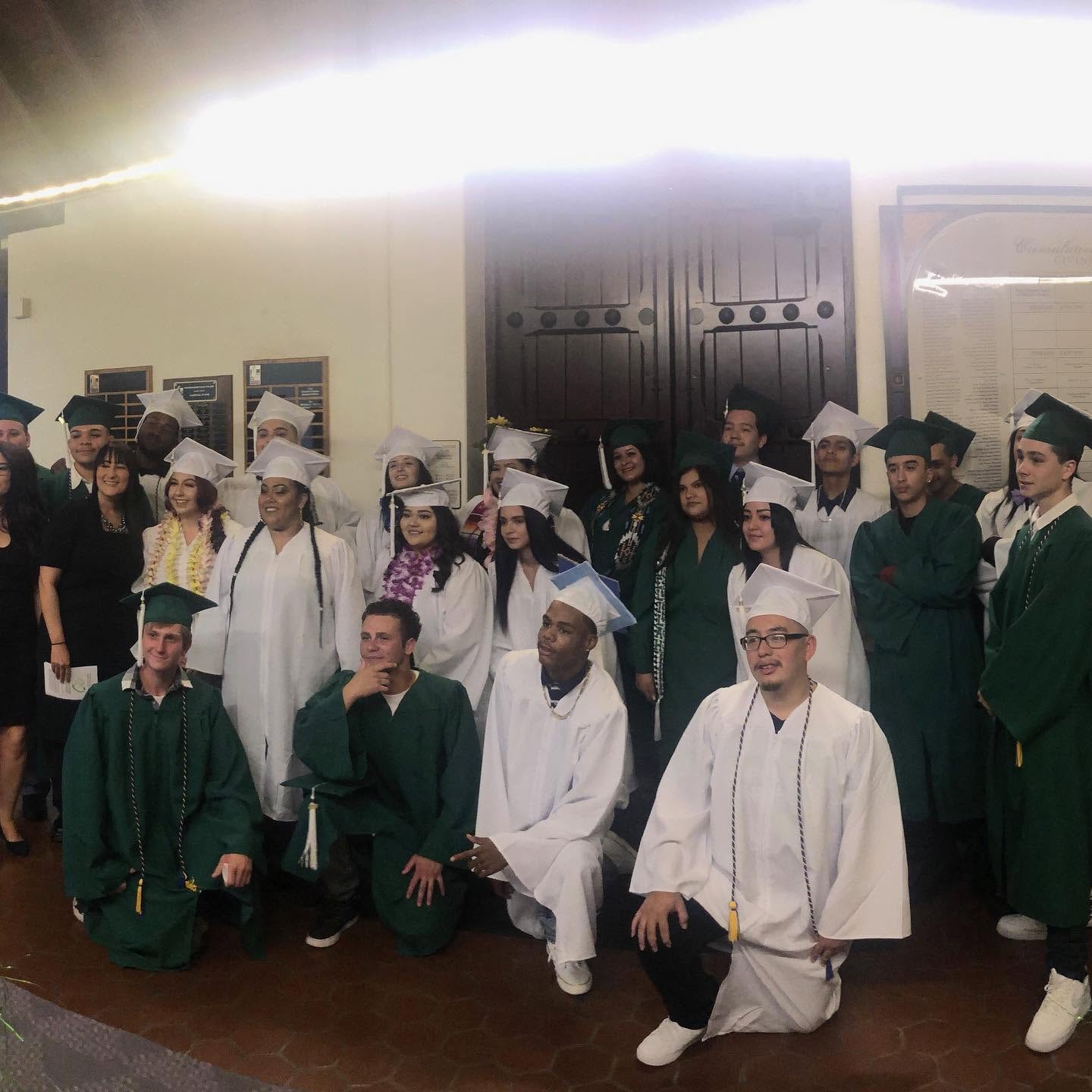Large group of Class of 2019 graduates in green and white caps and gowns at Operation New Hope