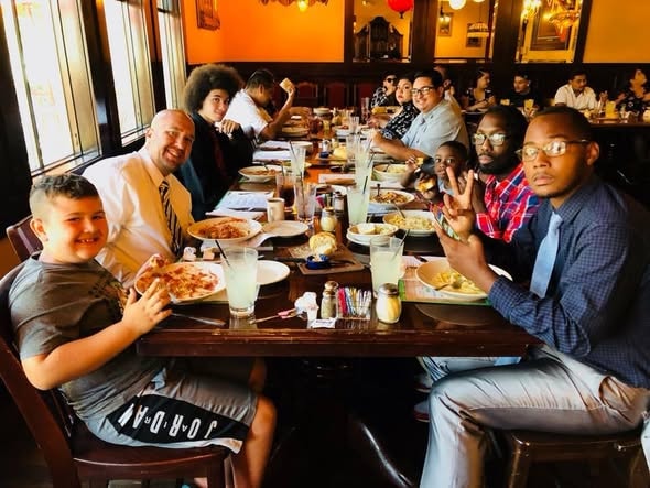 Group of graduates and supporters sharing a celebratory dinner together in 2018